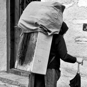 Rosa PANTE from LA MONG (Belluno district, Veneto, Italy), Via Campagna. Italian migrant trader before starting their sales tour in Innerferrera, Avers Valley (Graubünden, Switzerland). The merchandise bears the traveling trader in the box (trucha) on her back. (taken on 26 May 1970).